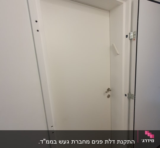 דלת לבנה עם ידית מתכת ומסגרת לבנה